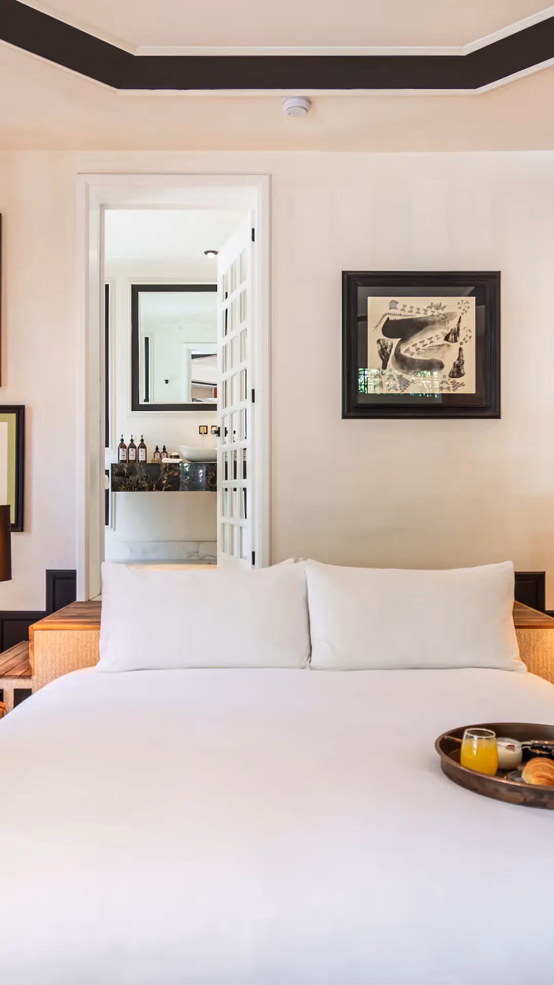Bright and elegant hotel room at La Valise Mexico City Hotel, featuring a welcome tray and refined design.