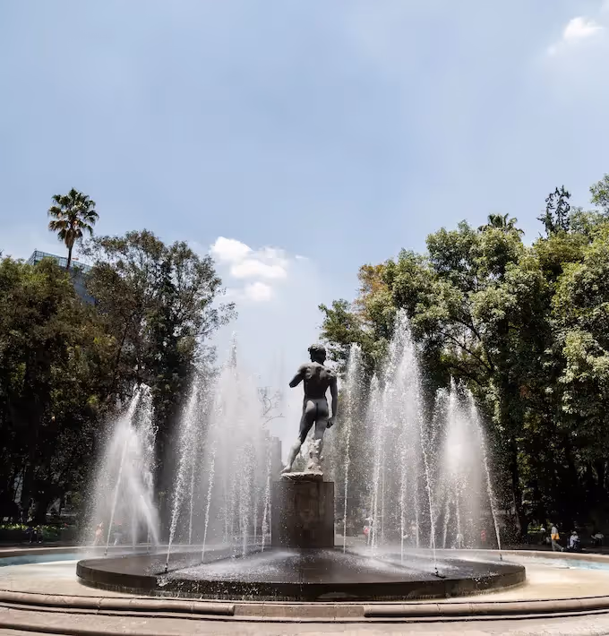 View of the Michelangelo's David replica fountain in a tree-lined park