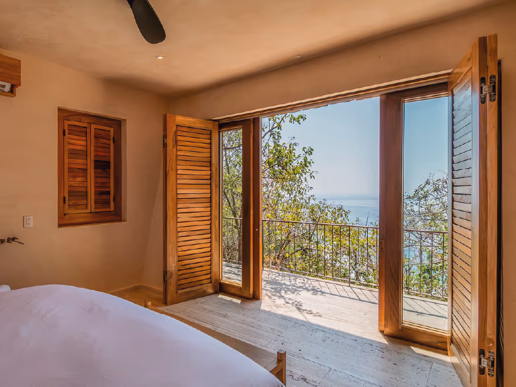 Tropical suite with large pivoting doors and sea views at La Valise Mazunte Hotel.