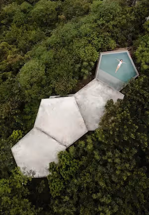 Aerial view of the modern architecture and rooftop pool at La Valise Mazunte Hotel restaurant and boutique hotel, surrounded by lush jungle in Mexico.