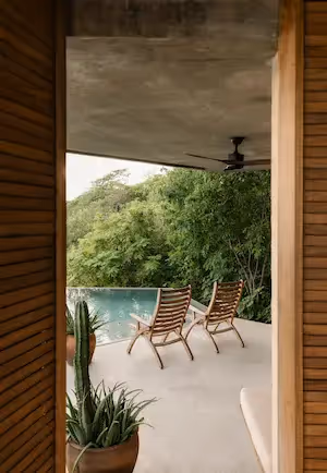 Shaded terrace with lounge chairs and jungle views at La Valise Mazunte Hotel.