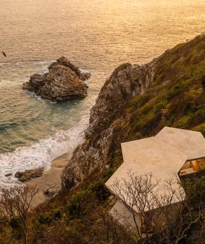 Bird's-eye view of the geometric architecture of La Valise Mazunte Hotel restaurant along the cliffs and turquoise waters.