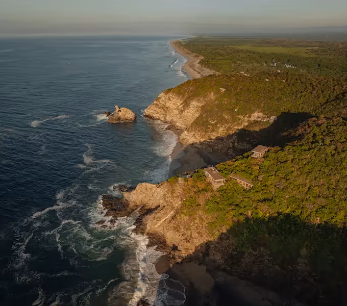 Illuminated tropical architecture and lush gardens at night at the entrance of La Valise Mazunte Hotel.