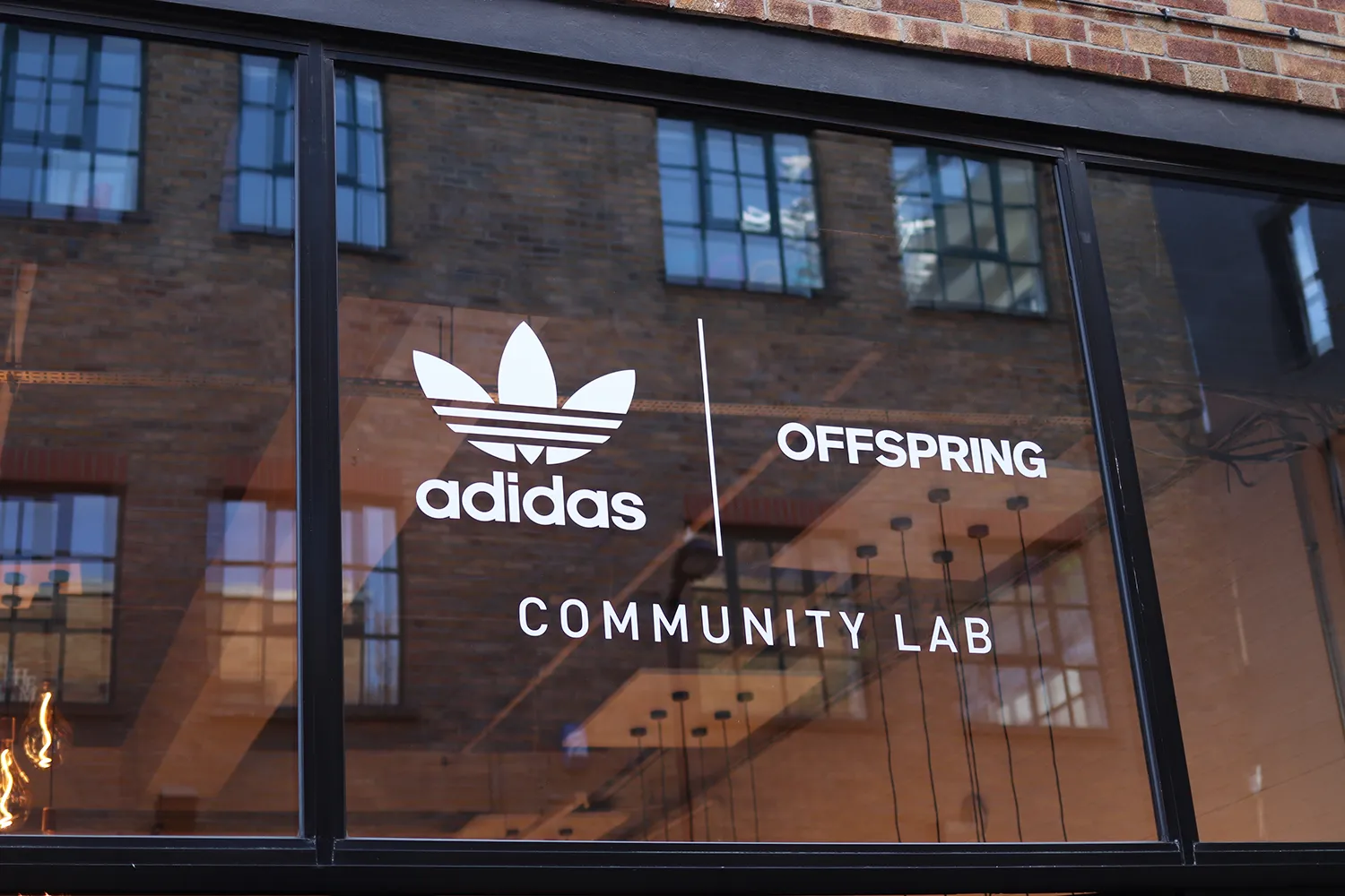 Window display showing Adidas and Offspring logos with the text Community Lab.