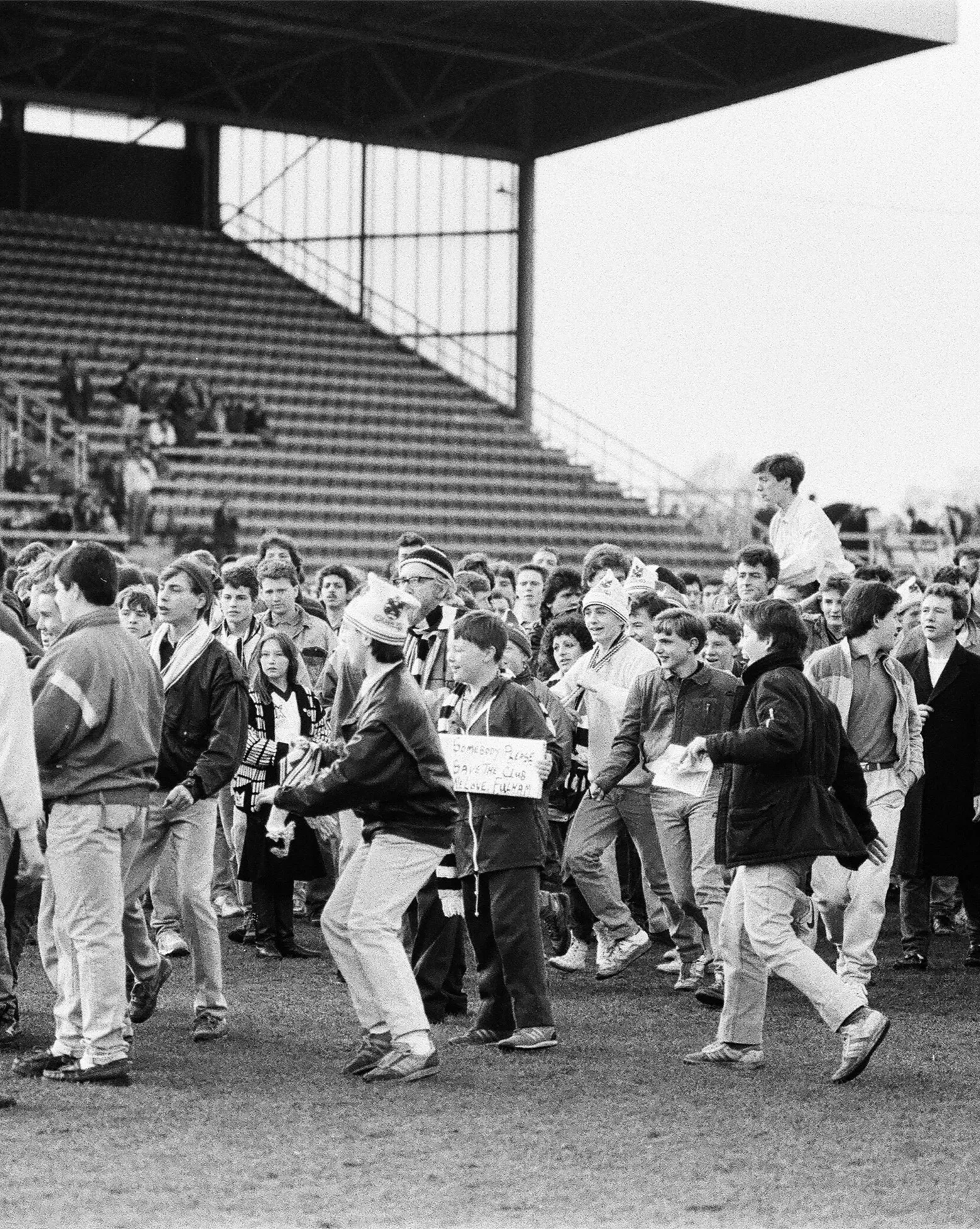 Archive image from the late 1980s showing football fans on a pitch wearing adidas trainers.