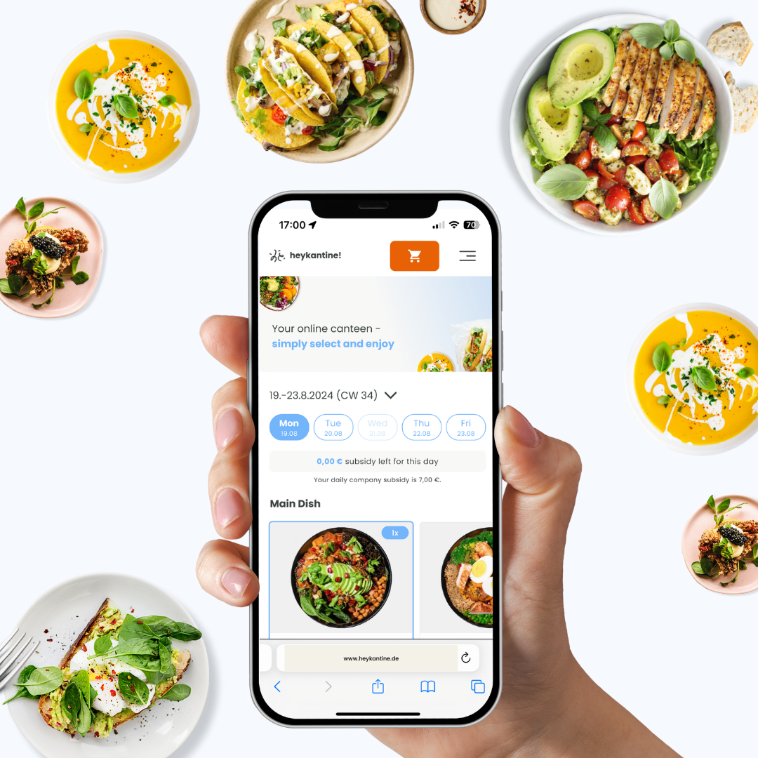 Hand hält Smartphone mit geöffneter Online-Kantinen-App, umgeben von bunten Gerichten wie Suppe, Tacos und Salat mit Hähnchen und Avocado.