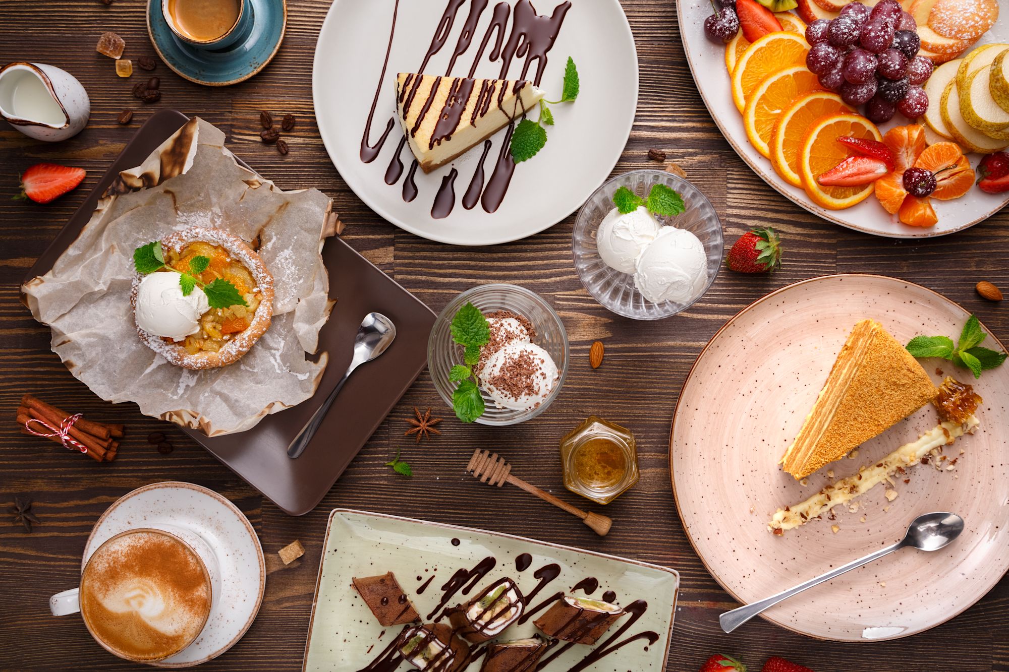 Vier lachende junge Erwachsene, zwei halten eine bunte Schüssel mit Salat und Falafel vor einem orangefarbenen Hintergrund.