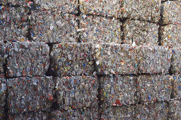 Baled stacks of compressed recycled PET plastic feedstock used to make acoustic felt panels.