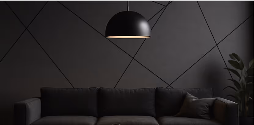 Dark lounge with geometric-patterned acoustic feature wall, dome pendant light and grey sofa.