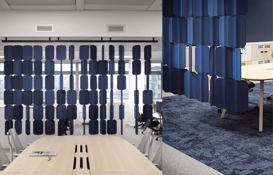 Blue felt acoustic hanging room divider screens separating workstations in an open-plan office.