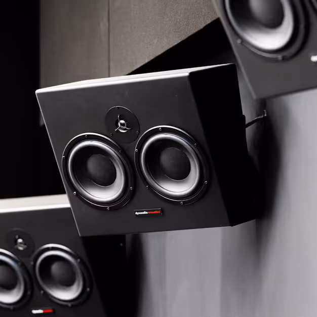 Dynaudio studio monitor speakers mounted in an acoustically treated recording room.