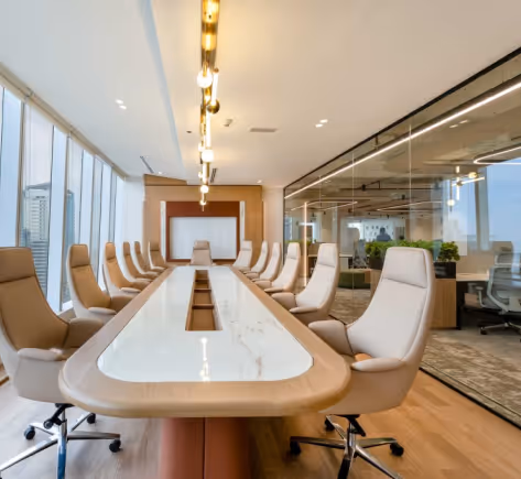 Boardroom with long marble table, leather chairs, and acoustic-treated glass partitions.