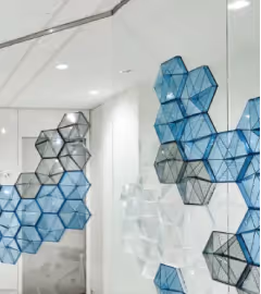 Blue hexagonal hanging acoustic dividers suspended as a sound-absorbing room partition.