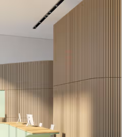 Wooden acoustic slat wall panels lining an office workspace for sound control.