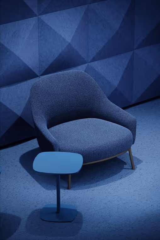 Blue 3D diamond acoustic wall panels behind a blue armchair and side table.