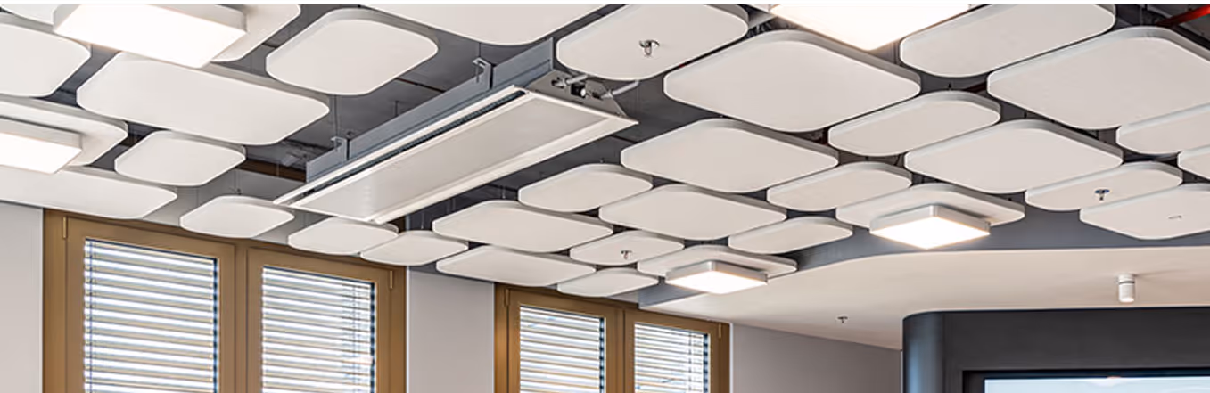 Grey and charcoal rectangular acoustic wall panels along a meeting room wall.