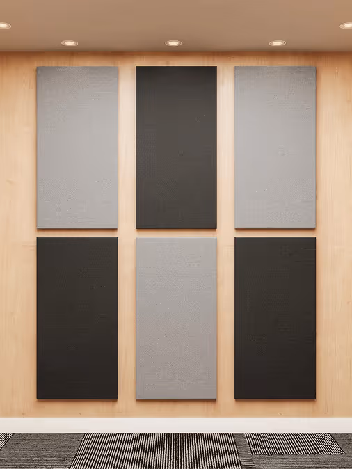 Grey hexagonal acoustic ceiling rafts with black pendant lights in an office.