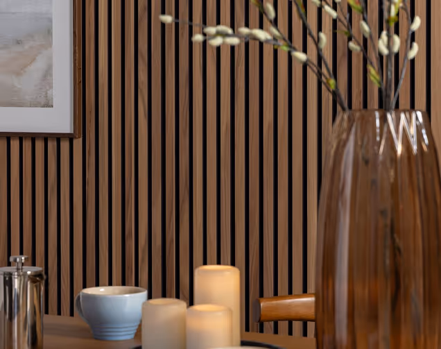 Wood-slat acoustic wall with a green cabinet and rattan chair.