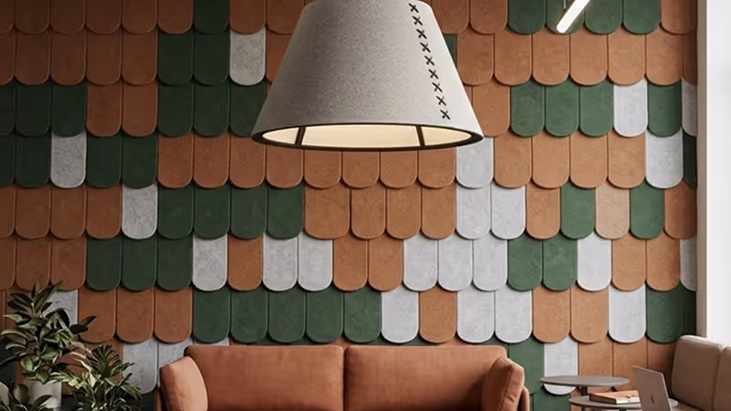 Green and terracotta scalloped felt acoustic wall tiles behind a lounge sofa.