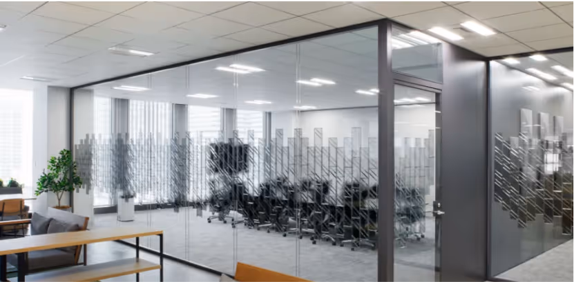 Glass-walled office meeting room with a patterned privacy and acoustic film.
