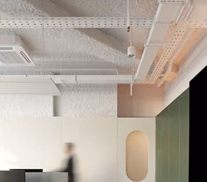 Open office with a white sprayed acoustic ceiling and exposed services above a reception area.