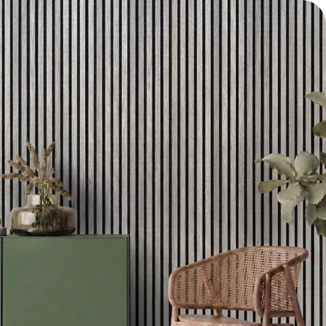Living room with a black charcoal acoustic wood slat wall, green sideboard, vase and rattan chair.