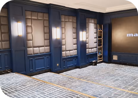 Interior fit-out in progress with navy coffered wall panels and floor protection.