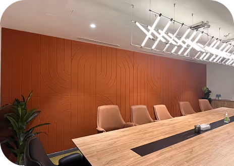 Meeting room with grooved terracotta acoustic wall panels, wood table and linear pendant light.