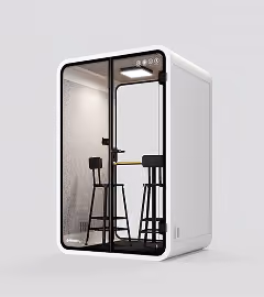 White freestanding acoustic office pod with glass door, bar stools and a high table inside.