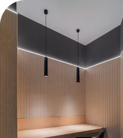 Wood-slat acoustic wall panels lining a booth with pendant lights and LED strip lighting.