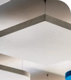 Suspended white hexagonal acoustic ceiling raft below a concrete ceiling.