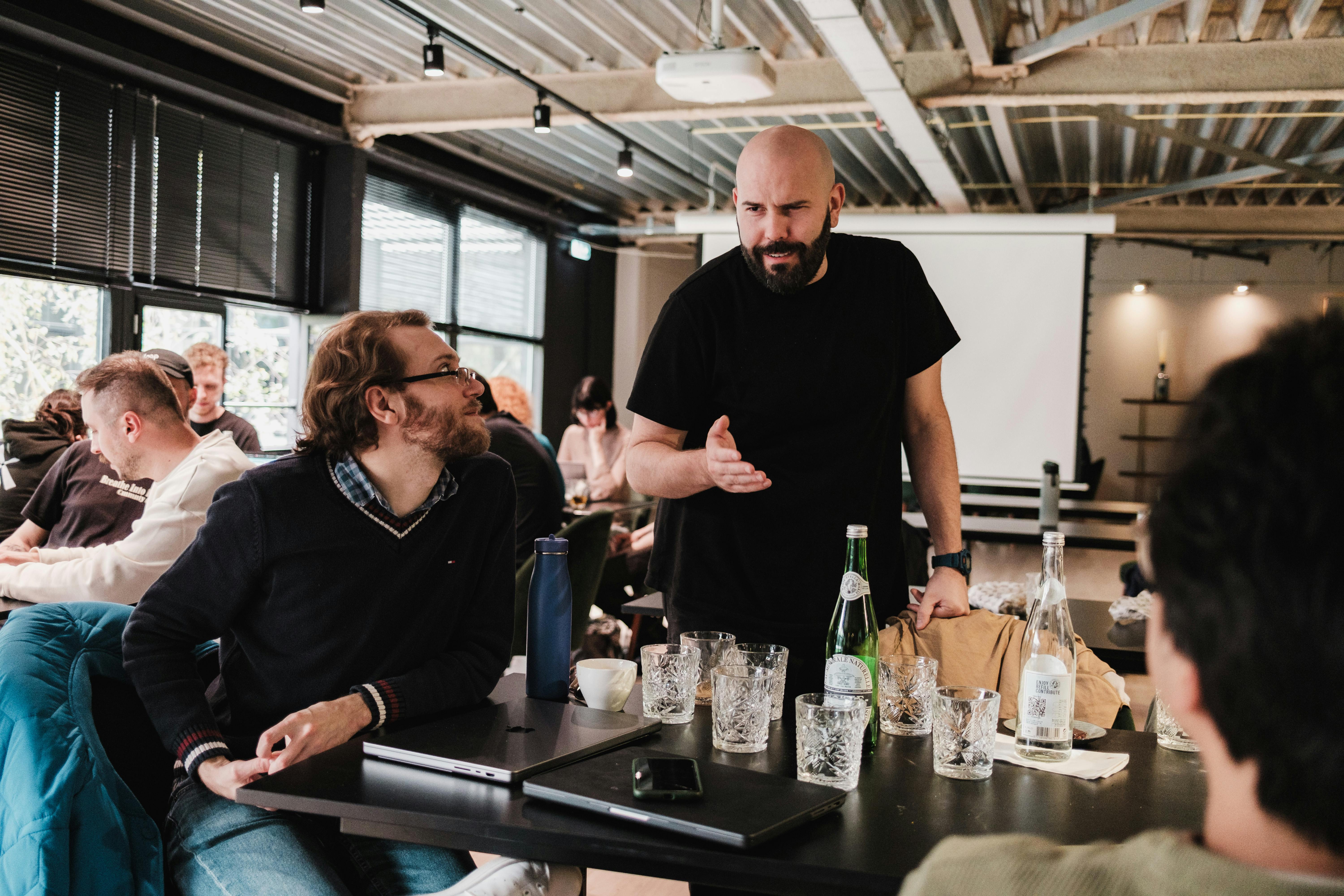 Reunión de trabajo en café moderno con personas conversando y bebiendo