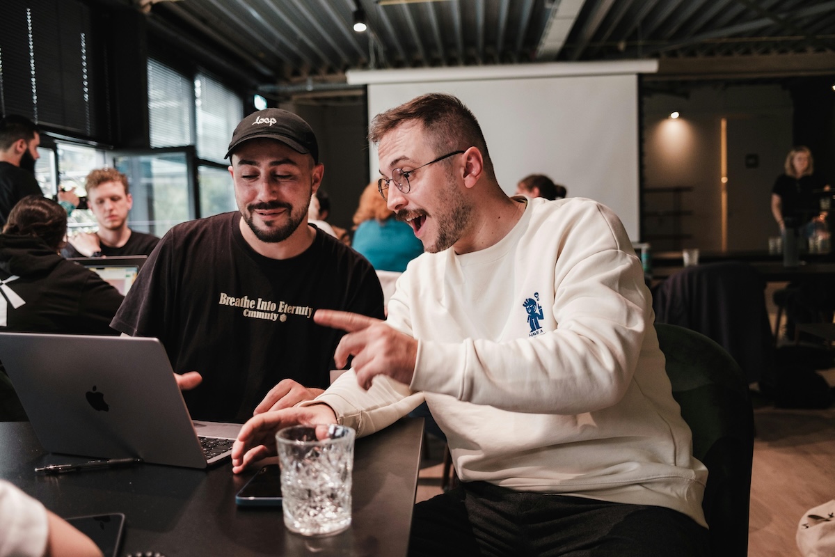 Dos hombres sonrientes trabajando juntos en una computadora portátil en una oficina