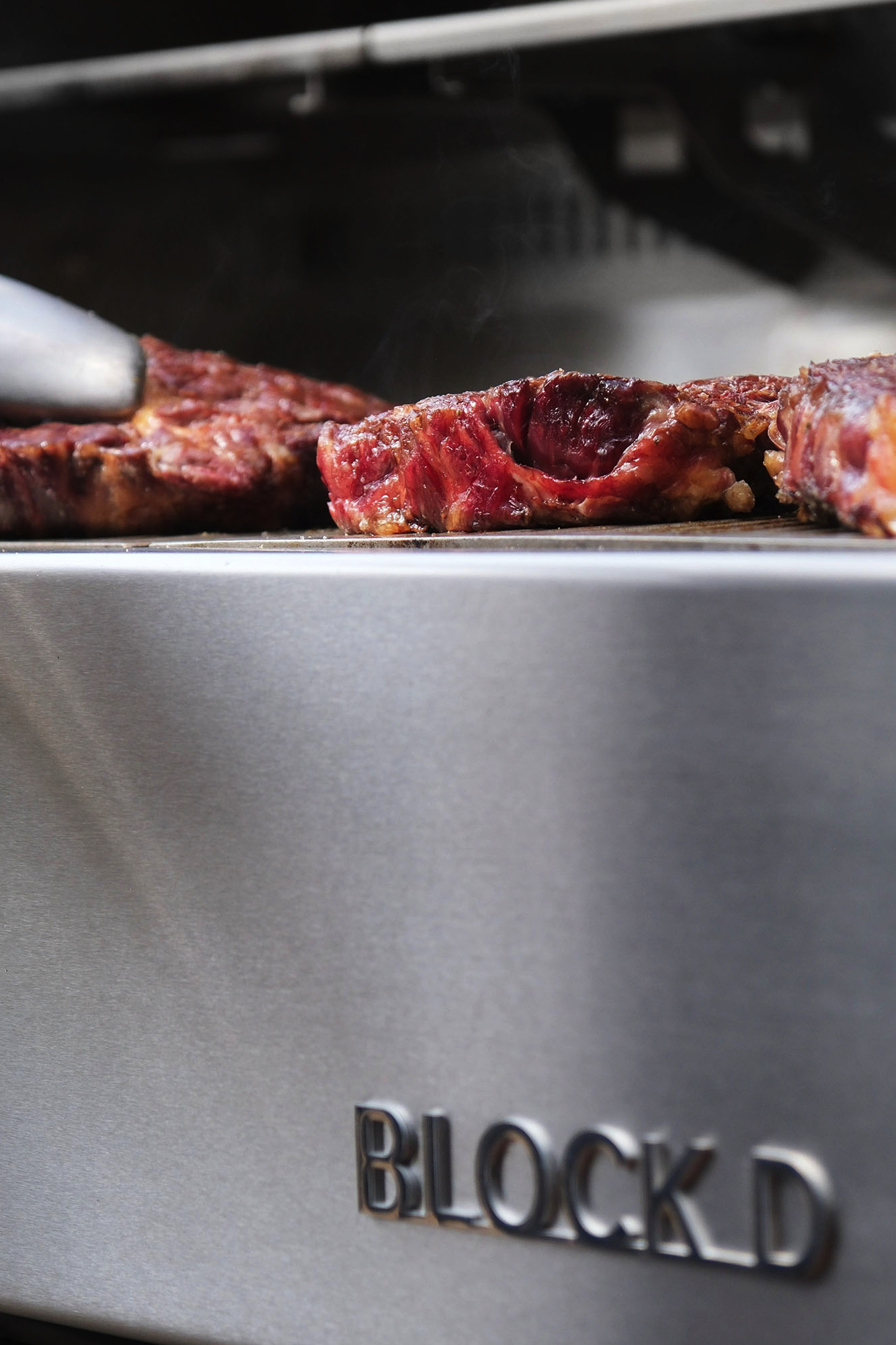 Flammkraft Block D stainless steel grill detail with searing steak on cooking surface