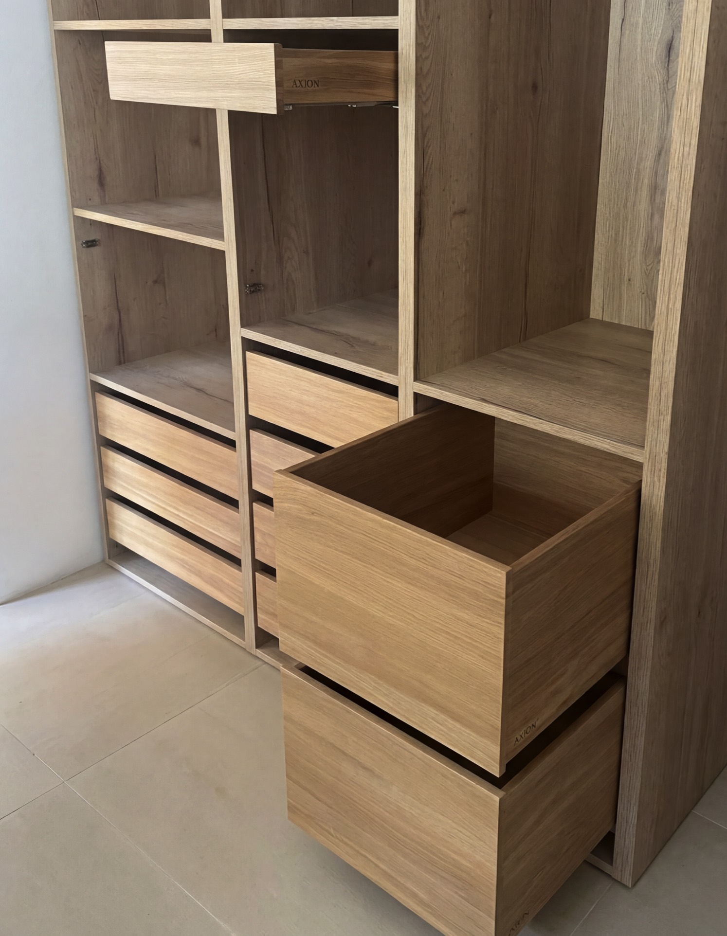 Custom oak wardrobe system with integrated drawers and precise carpentry detailing