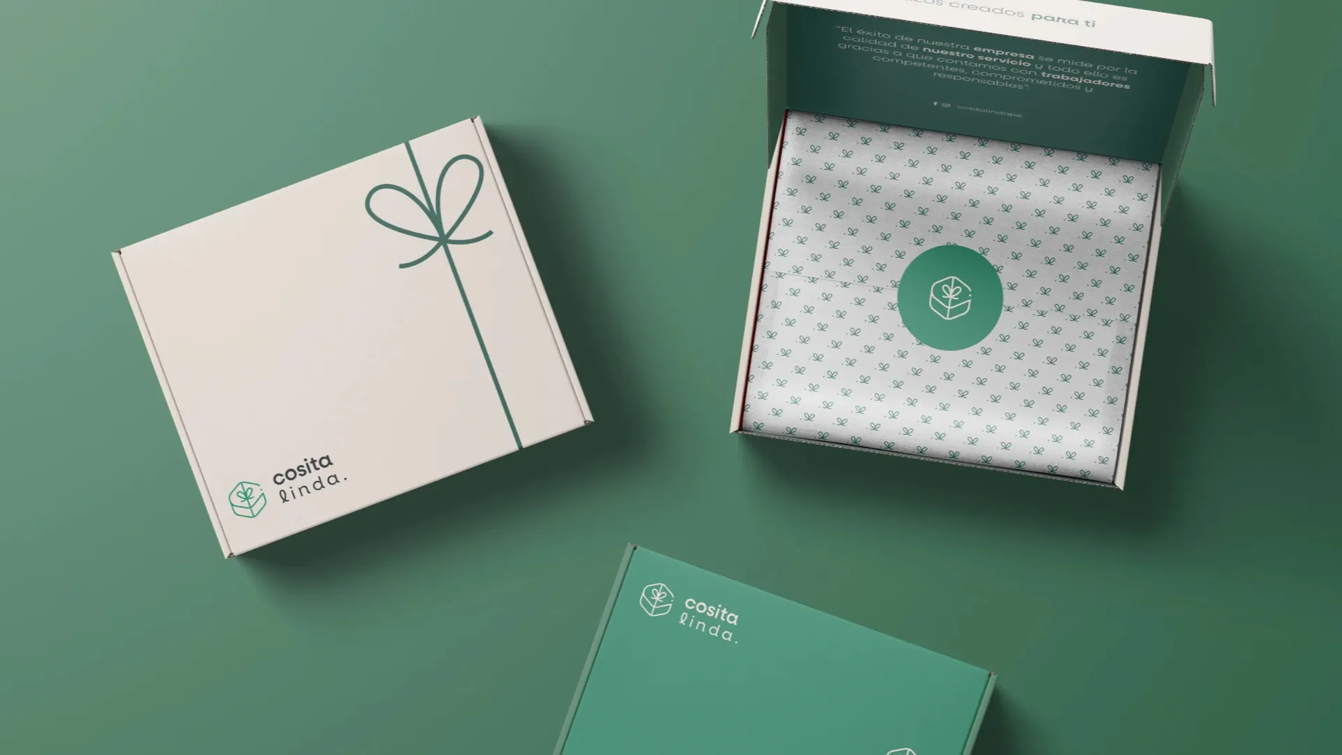 Mockup de packaging de regalo para la marca Cosita Linda mostrando cajas personalizadas en blanco y verde con papel de seda corporativo y diseño de lazo minimalista