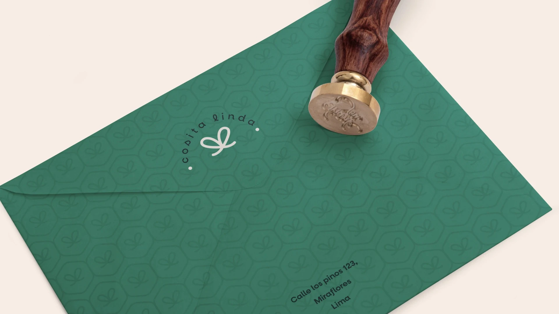Mockup de sobre de papelería corporativa verde de Cosita Linda con patrón de fondo y sello de lacre
