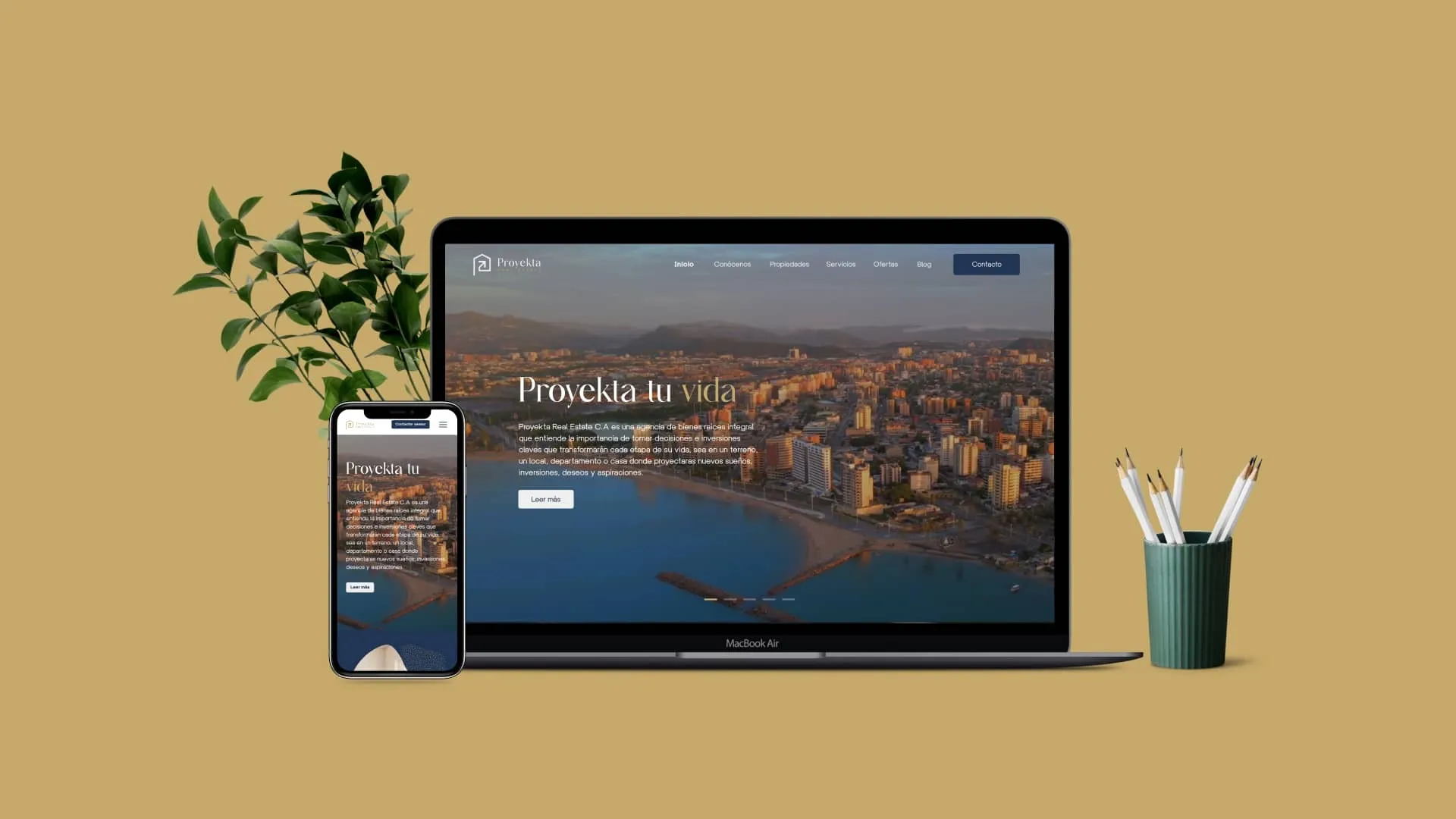 Mockup de sitio web inmobiliario visualizado en laptop y smartphone sobre escritorio minimalista