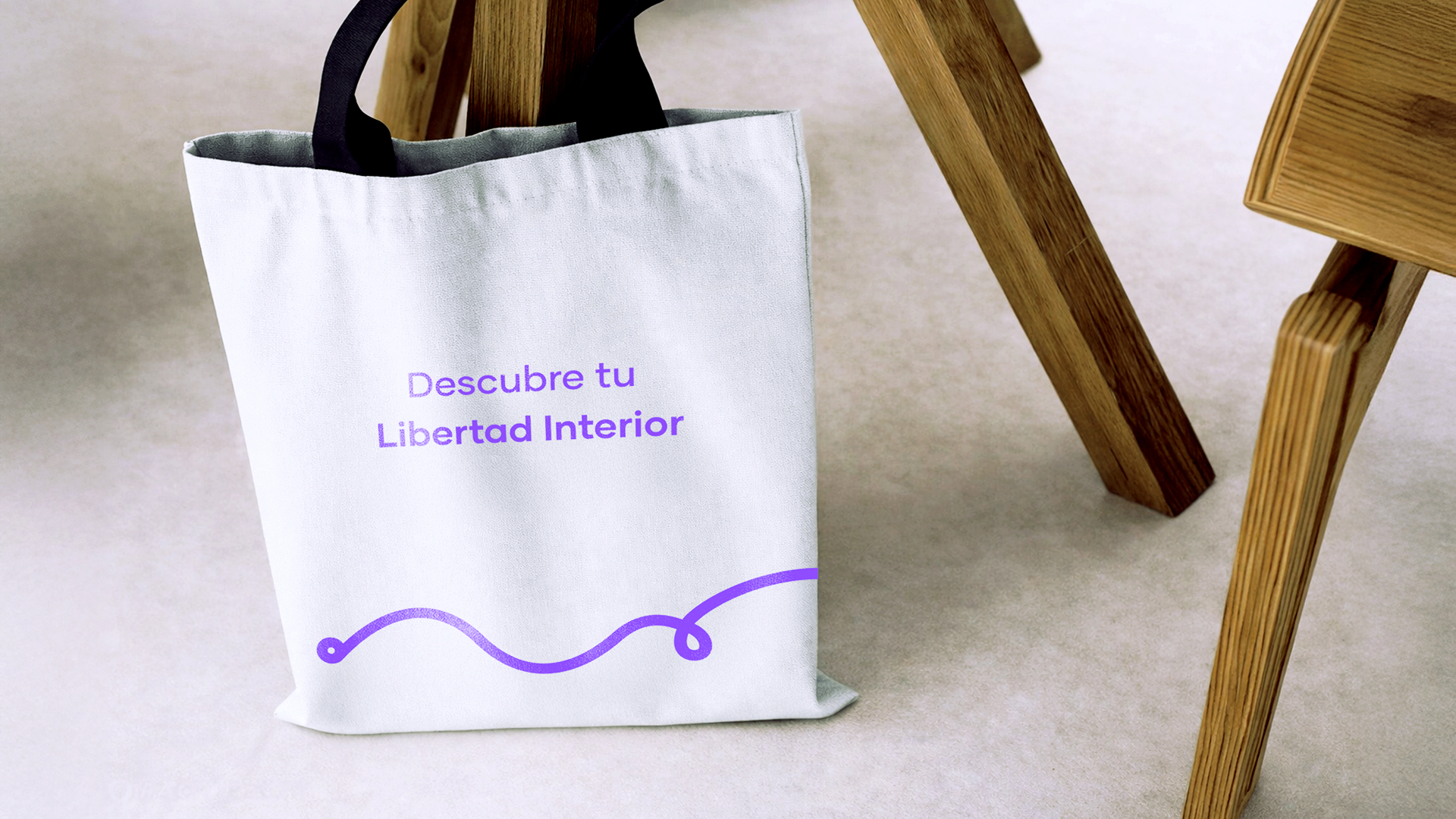 Bolsa de tela reutilizable con diseño de marca apoyada en silla