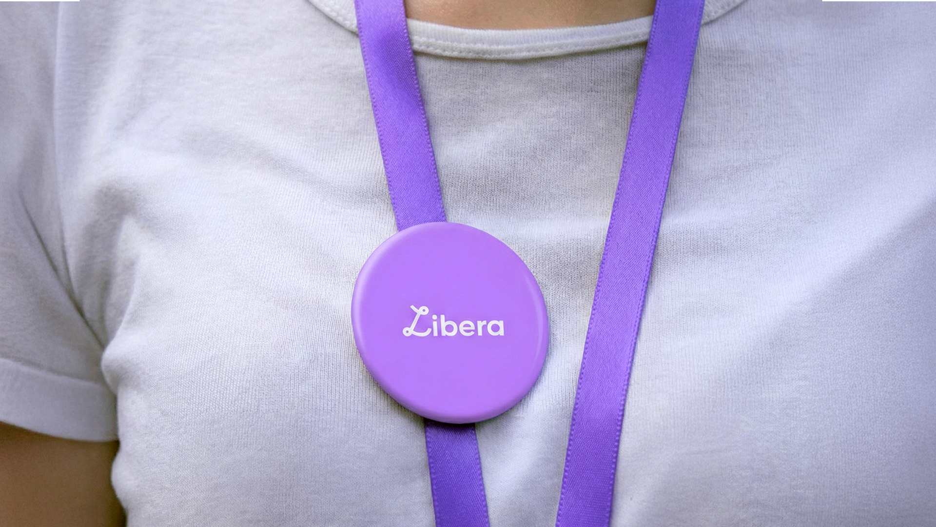 Detalle de pin circular con logotipo colocado sobre vestimenta