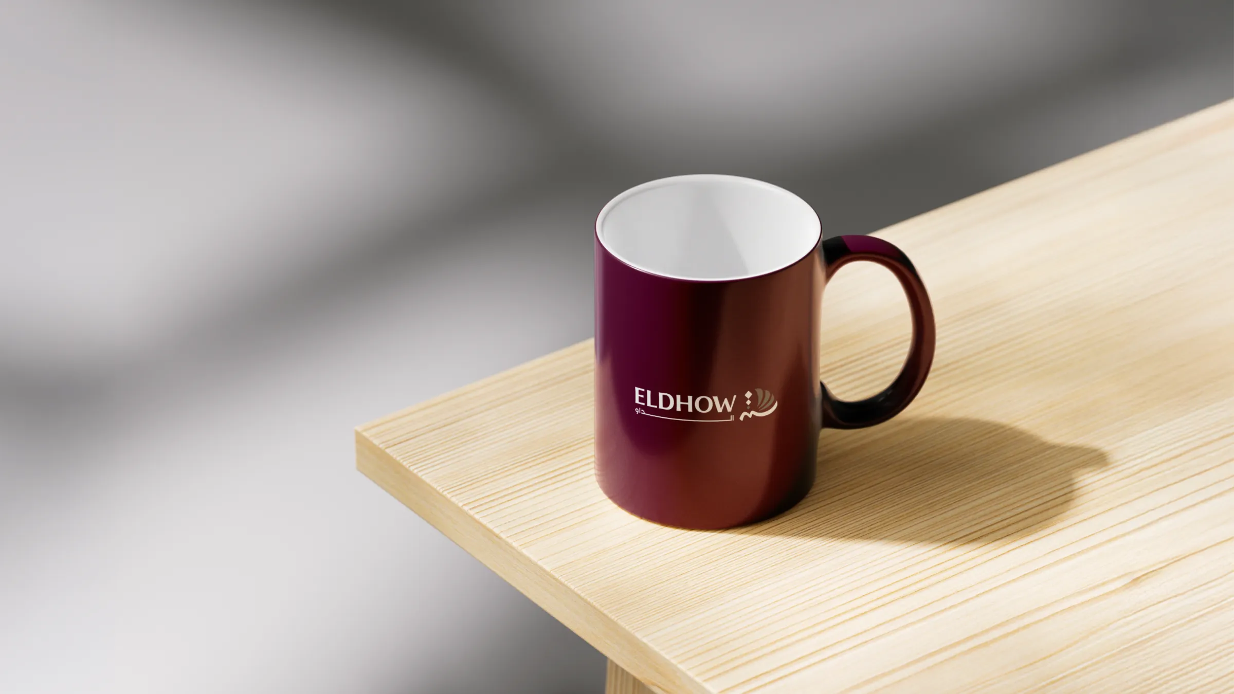 Taza corporativa color burdeos sobre mesa de madera