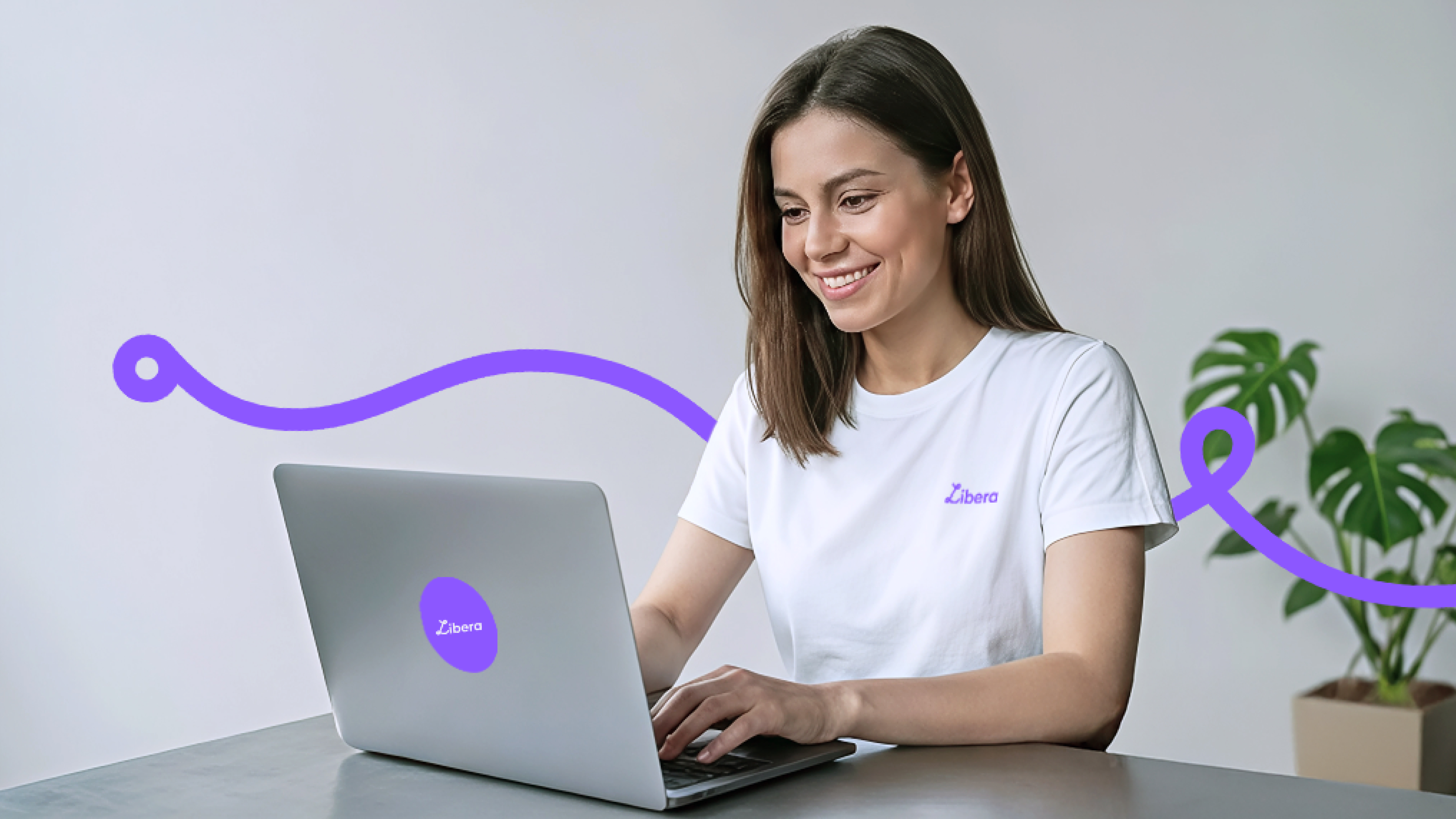 Persona trabajando en laptop con elementos gráficos curvos representando identidad de marca