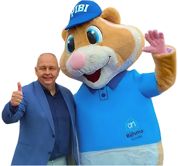 Man in blauw colbert geeft duim omhoog naast groot konijnpak met blauwe pet en shirt.