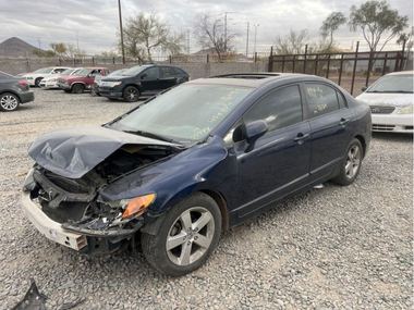 Unclaimed blue 2007 Honda Civic with a damaged hood parked in an impound lot