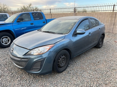 Unclaimed blue 2011 Mazda 3 parked in an impound lot