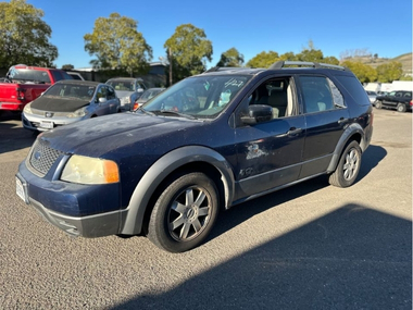 Unclaimed blue 2006 Ford Freestyle sitting in an impound lot