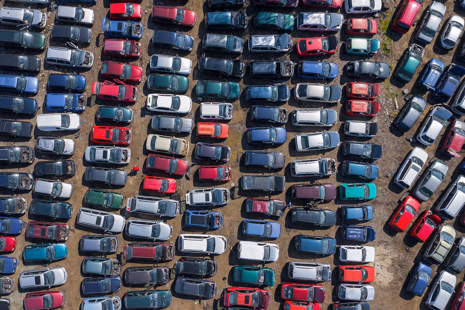 Overhead shot of an impound lot with towed and unclaimed vehicles of various colors and models
