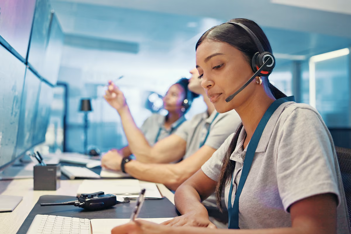 Dispatcher wearing a headset and taking notes