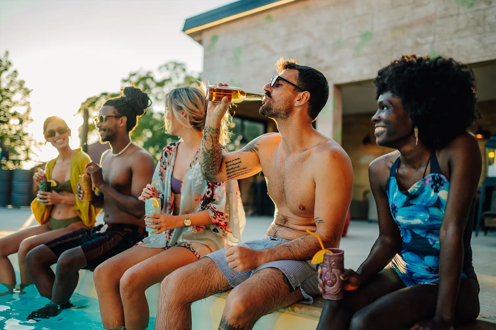 people sitting by pool with drinks stock image