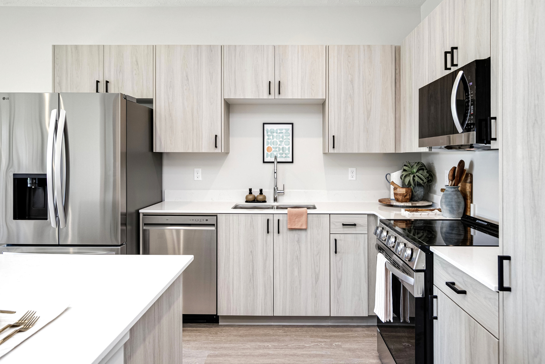 Kitchen with island, light wood cabinets and stainless steel appliances